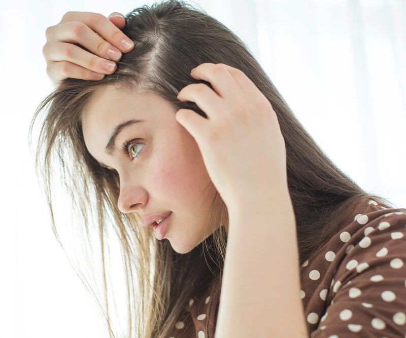 season hair loss, woman checking her hair